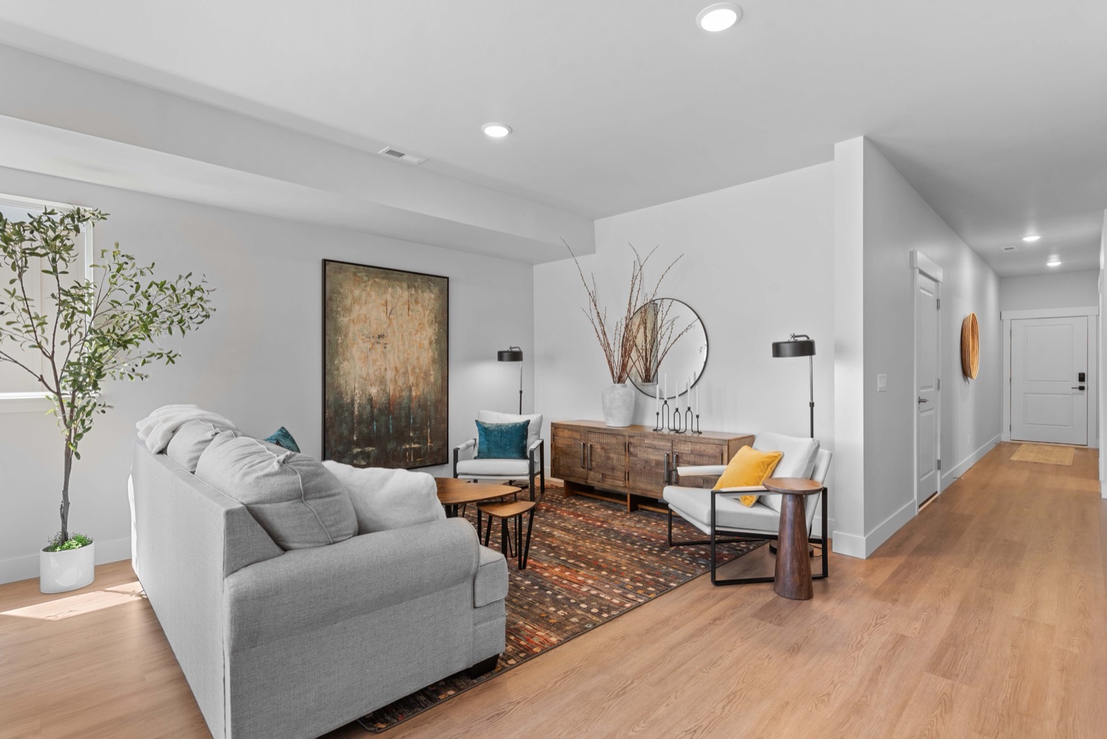 Staged living room at Springwater with light wood floors and patio access